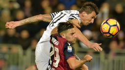 Duel pemain Juventus, Mario Mandzukic (atas) berduel dengan pemain Cagliari, Nicola Murru pada lanjutan Serie A di Sant'Elia Stadium, Cagliari (12/2/2017). (AFP/Giuseppe Cacace)