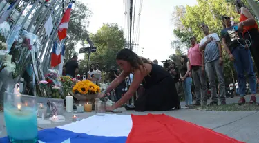 Seorang pendukung mantan Presiden Chile Sebastian Pinera meletakkan bunga di tugu peringatan untuk mengenangnya di luar rumahnya di Santiago pada tanggal 6 Februari 2024. (RAUL BRAVO/AFP)