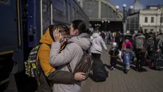 Seorang ibu memeluk putranya yang melarikan diri dari kota Mariupol yang terkepung dan tiba di stasiun kereta api di Lviv, pada 20 Maret 2022. Pada Hari 25 perang Rusia di Ukraina, kehidupan yang kacau, perpisahan yang pahit tertangkap dalam foto-foto Associated Press. (AP Photo/Bernat Armangue)