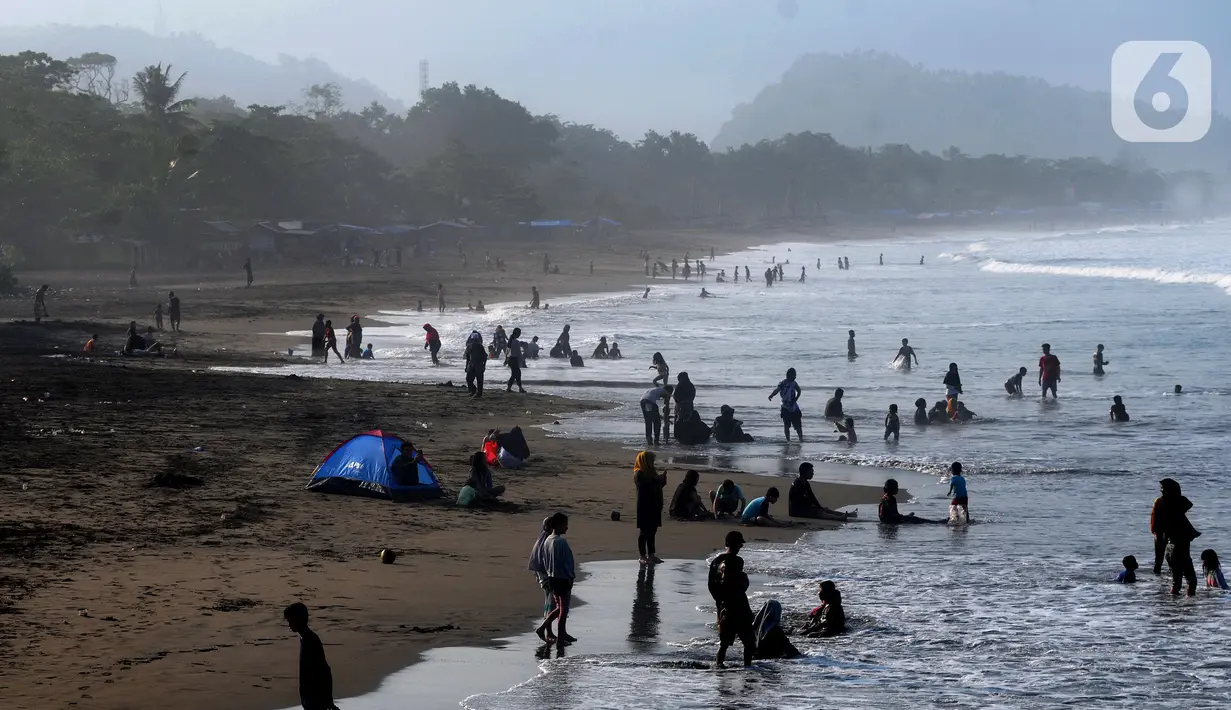 Wisatawan beraktifitas di pinggir pantai di kawasan Pantai Karang Naya, Pelabuhan Ratu, Sukabumi, Selasa (1/6/2021). Walaupun liburan lebaran telah usai sejumlah pantai di kawasan Pelabuhan Ratu masih dipadati pengunjung yang berasal dari Kota Jakarta dan Jawa Barat.(merdeka.com/Arie Basuki)