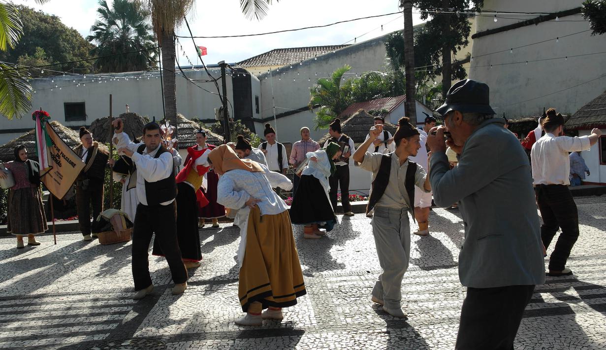 Sejumlah warga menari tarian tradisional khas Funchal, Portugal. Kota ini merupakan tempat bintang Real Madrid, Cristiano Ronaldo, lahir dan dibesarkan. (Bola.com/Reza Khomaini)