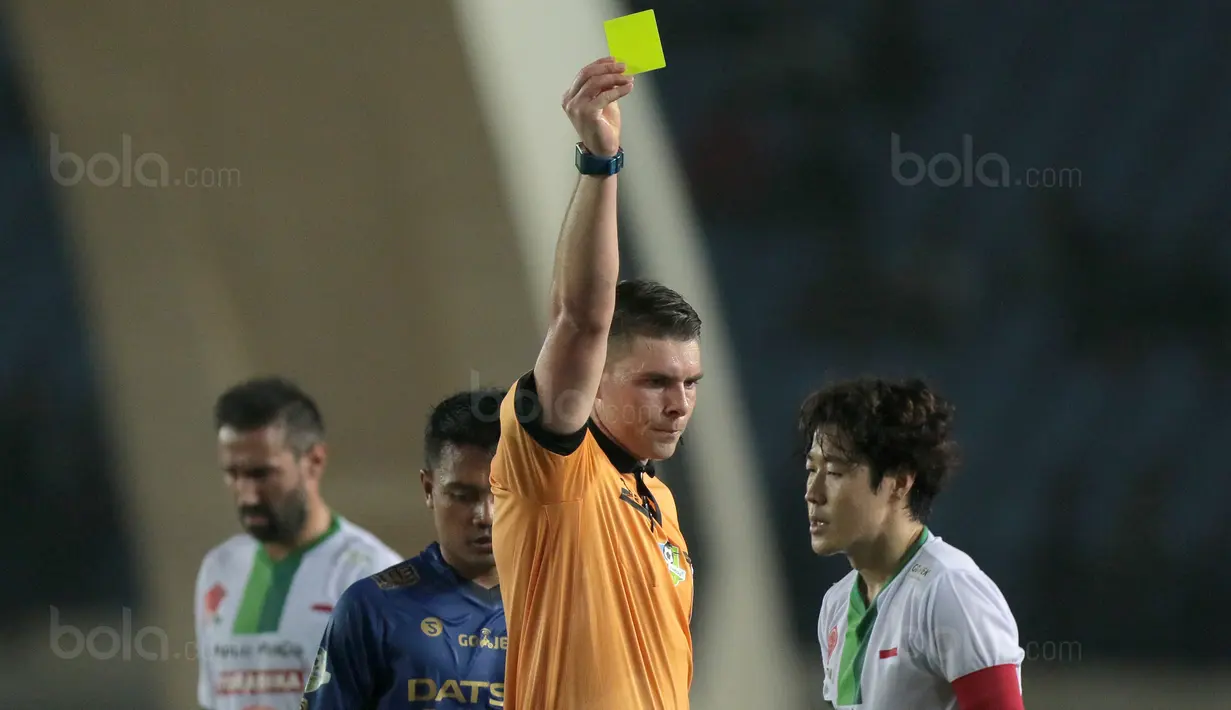 Wasit Evan Shaun Robert memberikan kartu kuning kepada pemain PS TNI, Hong Soon-hak saat laga melawan Persib Bandung pada lanjutan Liga 1 2017 di Stadion Si Jalak Harupat, Sabtu (05/8/2017). (Bola.com/Nicklas Hanoatubun)