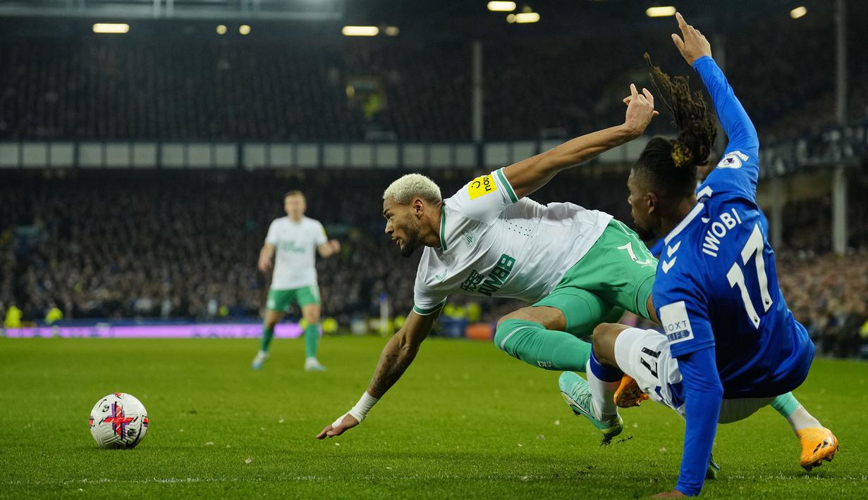 Pemain Newcastle, Joelinton (kiri) berebut bola dengan pemain Everton, Alex Iwobi pada laga pekan ke-33 Liga Inggris 2022/2023 di Goodison Park, Liverpool, Jumat (28/04/2023) dini hari WIB. The Magpies sukses menghajar tuan rumah dengan skor 4-1. (AP Photo/Jon Super)