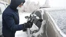 Seorang penduduk setempat menyingkirkan es dari mobilnya di Changchun, Provinsi Jilin, China timur laut, pada 19 November 2020. Hujan lebat dan salju yang jarang terjadi disertai angin kencang melanda Changchun pada 18 dan 19 November. (Xinhua/Xu Chang)