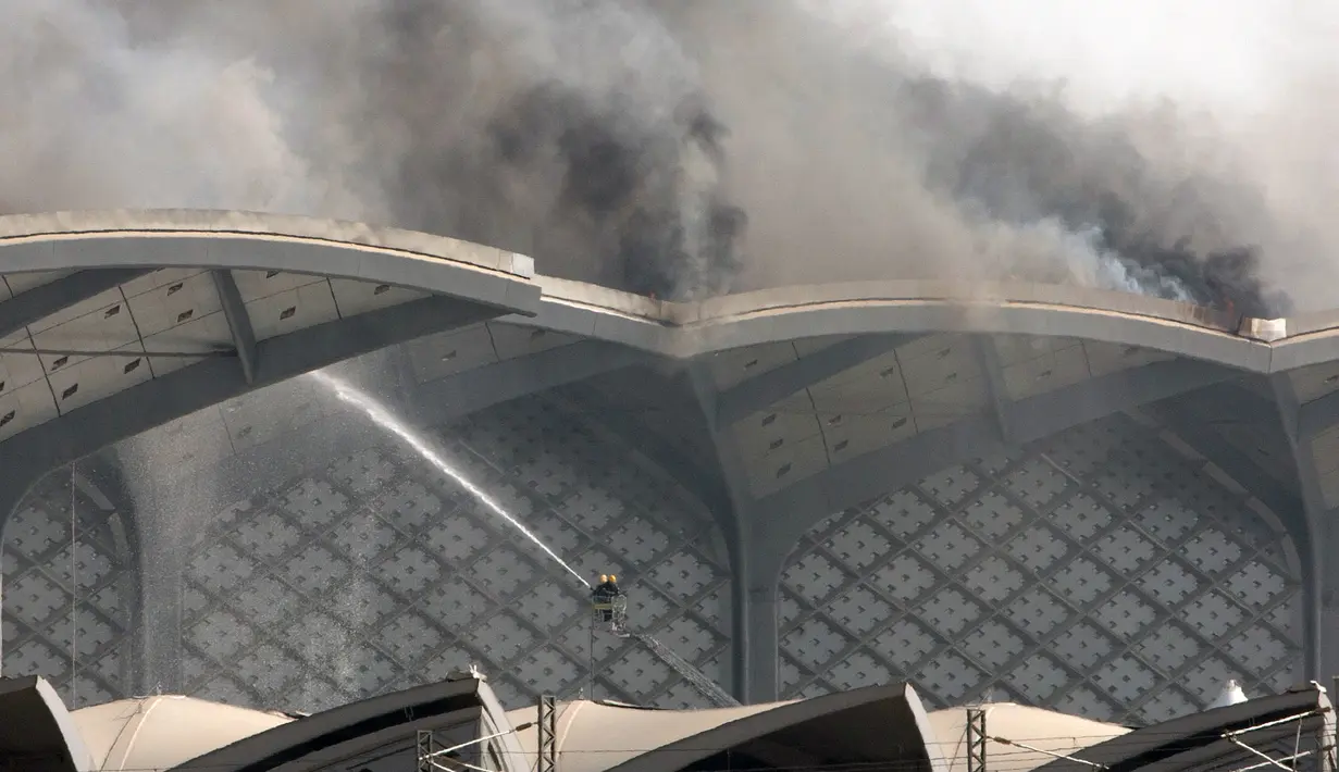 Pasukan Pertahanan Sipil Arab Saudi memadamkan kebakaran yang melanda Stasiun Kereta Api Cepat Haramain di kota Jeddah, Minggu (29/9/2019). Kebakaran terjadi pada pukul 12.35 waktu setempat di atap lantai empat gedung stasiun. (Photo by - / AFP)