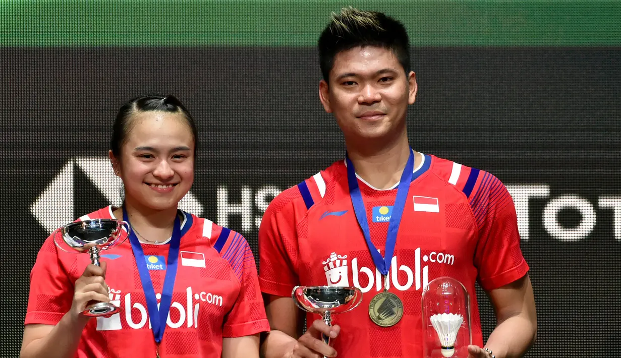 Pasangan Indonesia Praveen Jordan/Melati Daeva Oktavianti memerkan medali usai mengalahkan pasangan Thailand Dechapol Puavaranukroh/Sapsiree Taerattanachai pada laga final ganda campuran All England 2020 di Birmingham, Inggris, Minggu (15/3/2020). Indonesia menang 2-1. (AP Photo/Rui Vieira)