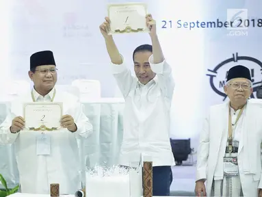 Dua pasang capres-cawapres Prabowo Subianto-Sandiaga Uno dan Joko Widodo-Ma'ruf Amin menunjukan nomor urut peserta Pemilu 2019 di Kantor KPU, Jakarta, Jumat (21/9).  (Liputan6.com/Faizal Fanani)