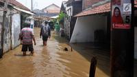 Sejumlah warga melintasi genangan banjir di kawasan Sawah besar Semarang, Jawa Tengah, Sabtu (8/12). Ratusan rumah tergenang banjir akibat Tanggul Sungai Banjir Kanal Timur jebol. (Liputan6.com/Gholib)