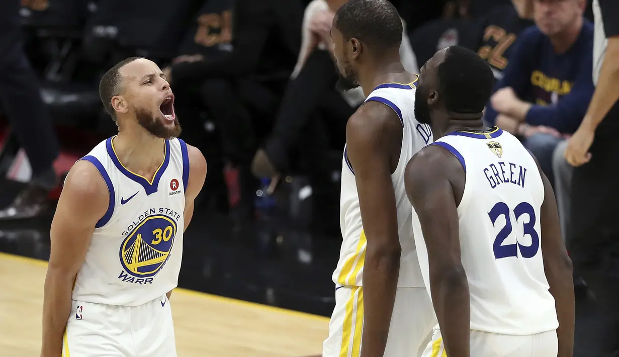 Pemain Warriors, Kevin Durant, Stephen Curry, left, dan Draymond Green (23) merayakan kemenangan atas Cavaliers pada gim ketiga final NBA basketball di Quicken Loans Arena, (6/6/2018). Warriors kalahkan Cavaliers 110-102. (AP/Carlos Osorio)