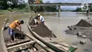 Aktivitas penambang saat bongkar muat pasir dari perahu di Sungai Klawing, Desa Toyarejo, Purbalingga, Jawa Tengah, Minggu (15/5/2022). Sehudin (62) salah satu penambang mengungkapkan para pekerja mampu menggali pasir dan memuat 10 hingga 50 truk dalam sehari. Tiap satu perahu mampu mengangkut 1 meter kubik dengan harga upah Rp110.000. (merdeka.com/Iqbal S Nugroho)