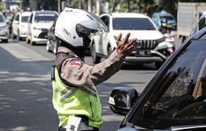 Polisi lalu lintas berkomunikasi dengan pengendara mobil saat Operasi Zebra Jaya 2022 di Jakarta, Selasa (4/10/2022). Operasi Zebra Jaya dilaksanakan pada tanggal 3 hingga 17 Oktober untuk menekan jumlah pelanggaran lalu lintas. (Liputan6.com/Faizal Fanani)