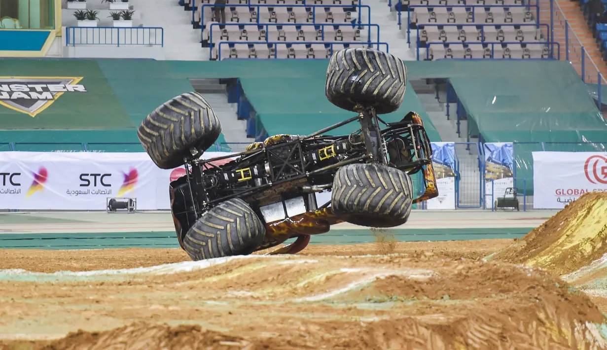 Truk monster terguling saat melewati rintangan selama pertunjukan Monster Jam di stadion Raja Fahad, Riyadh, Arab Saudi, Jumat (17/3). Acara ini diselenggarakan General Entertainment Authority. (AFP Photo/Fayez Nureldine)