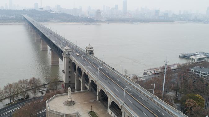 Foto dari udara yang diabadikan pada 27 Januari 2020 ini menunjukkan Jembatan Sungai Yangtze di Wuhan, Provinsi Hubei, China tengah. Warga di Wuhan tetap menjalani kehidupan sehari-hari mereka saat upaya terus dilakukan untuk mengendalikan wabah coronavirus baru. (Xinhua/Cheng Min)