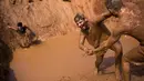 Peserta membantu rekannya saat mengikuti Mud Day di Tel Aviv, Israel (24/3). Total ada 22 rintangan yang harus dilewati antara lain berayun di antara tambang, mendaki bukit berlumpur, dan merangkak di atas air berlapis es. (AP Photo/Oded Balilty)