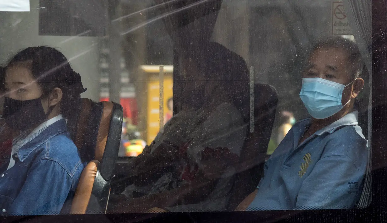 Para penumpang memakai masker saat menaiki bus di Bangkok, Thailand pada Senin (4/1/2021). Pejabat kesehatan di Thailand pada Senin mencatat 745 kasus virus corona baru, rekor tertinggi harian di negara itu sejak pandemi COVID-19 melanda Negeri Gajah Putih pada Februari 2020. (Jack TAYLOR / AFP)