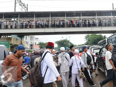 Peserta aksi 2 Desember memadati jembatan penyeberangan orang (JPO) di kawasan Pasar Baru, Jakarta, Jumat (2/12). Aksi berjalan lancar dan damai. (Liputan6.com/Helmi Afandi)
