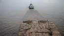 Sebuah kapal tongkang berisi kayu gelondongan ditarik di sepanjang Sungai Mahakam melewati Kota Samarinda, Kalimantan Timur, 4 November 2021. (ADITYA AJI/AFP)