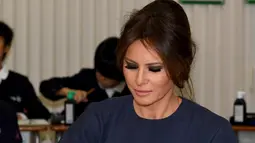 Ibu Negara AS Melania Trump menulis kanji saat menghadiri kelas kaligrafi di sekolah dasar Kyobashi Tsukiji, Tokyo (6/11). Melania Trump dan Akie Abe menulis huruf kanji yang berarti "Damai". (AFP Photo/Pool/Toshifumi Kitamura)