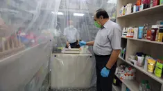 Lapisan plastik digunakan untuk mengurangi kontak fisik antara pegawai dengan pembeli di sebuah apotek di Baghdad, Irak, Selasa (14/4/2020). Menjaga jarak fisik atau physical distancing dinilai langkah paling tepat untuk mengurangi penyebaran virus corona COVID-19. (Xinhua)