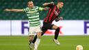 Gelandang AC Milan, Rade Krunic, Berebut bola dengan gelandang Celtic, Scott Brown, pada laga Grup H Liga Europa 2020/2021 di Celtic Park Stadion, Jumat (23/10/2020). AC Milan menang 3-1 atas Celtic. (AFP/Russell Cheyne/pool)