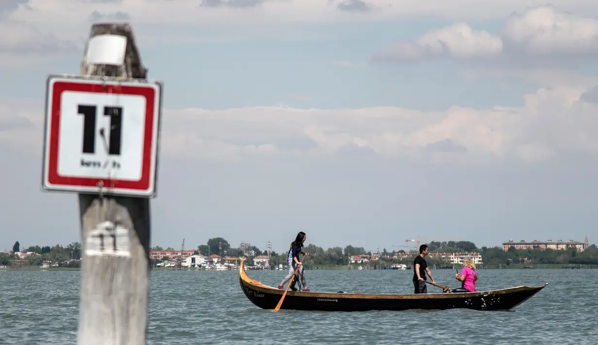 Perempuan yang tergabung dalam Row Venice menawarkan pengalaman belajar mendayung gondola di sebuah kanal di Venesia, Italia pada 16 Mei 2019. Row Venice merupakan organisasi nonprofit bentukan sekelompok perempuan yang berfokus pada pelestarian seni mendayung perahu. (MARCO BERTORELLO/AFP)