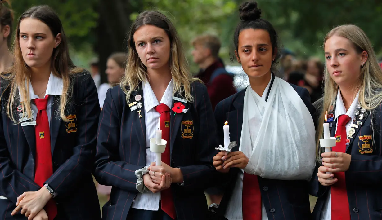 Para pelajar menggelar aksi lilin saat mengenang korban penembakan di luar Masjid Al Noor, Christchurch, Selandia Baru, Senin (18/3). Penembakan tersebut merupakan serangan terburuk dalam sejarah Selandia Baru modern. (AP Photo/Vincent Yu)