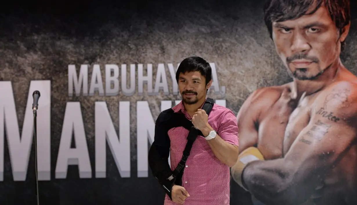Manny Pacquiao berpose saat di sambut di Bandar udara Internasional Manila. (AFP PHOTO/TED ALJIBE)
