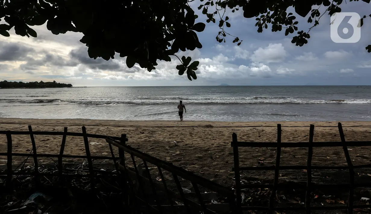 Seseorang terlihat di pantai Carita, Pandeglang, Banten, Selasa (18/1/2022). Objek wisata Pantai Carita yang menjadi tempat favorit pengunjung kini tampak sepi seusai gempa beberapa waktu lalui dan juga lantaran naikknya kasus virus covid 19 varian omicron. (Liputan6.com/Johan Tallo)