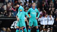 Pemain Barcelona, Lionel Messi dan Frenkie de Jong, terlihat lemas saat Valencia berhasil mencetak gol ke gawang Barcelona. Valencia menang 2-0 atas Barcelona di Mestalla, dalam laga jornada 21 La Liga, Sabtu (25/1/2020). (Jose Jordan/AFP)