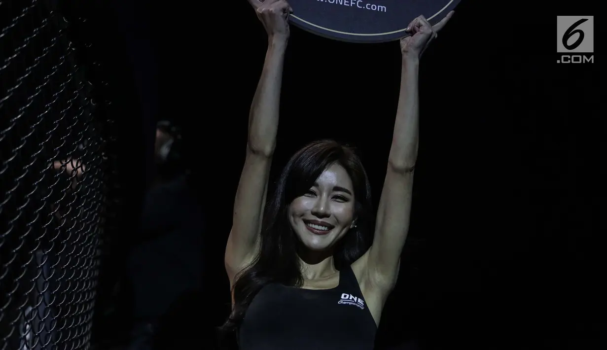 Seorang Ring Girl membawa papan ronde saat pertarungan ONE Championship di Jakarta Convention Center, Sabtu (20/1). Gadis-gadis itu mengenakan pakaian minim dan berjalan mengitari arena sebagai pertanda pergantian ronde. (Liputan6.com/Faizal Fanani)