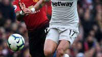 Striker West Ham United, Javier Hernandez berusaha menggiring bola dari kejaran gelandang Manchester United, Fred selama pertandingan lanjutan Liga Inggris di Old Trafford (13/4). MU menang tipis atas West Ham 2-1. (AFP Photo/Paul Ellis)