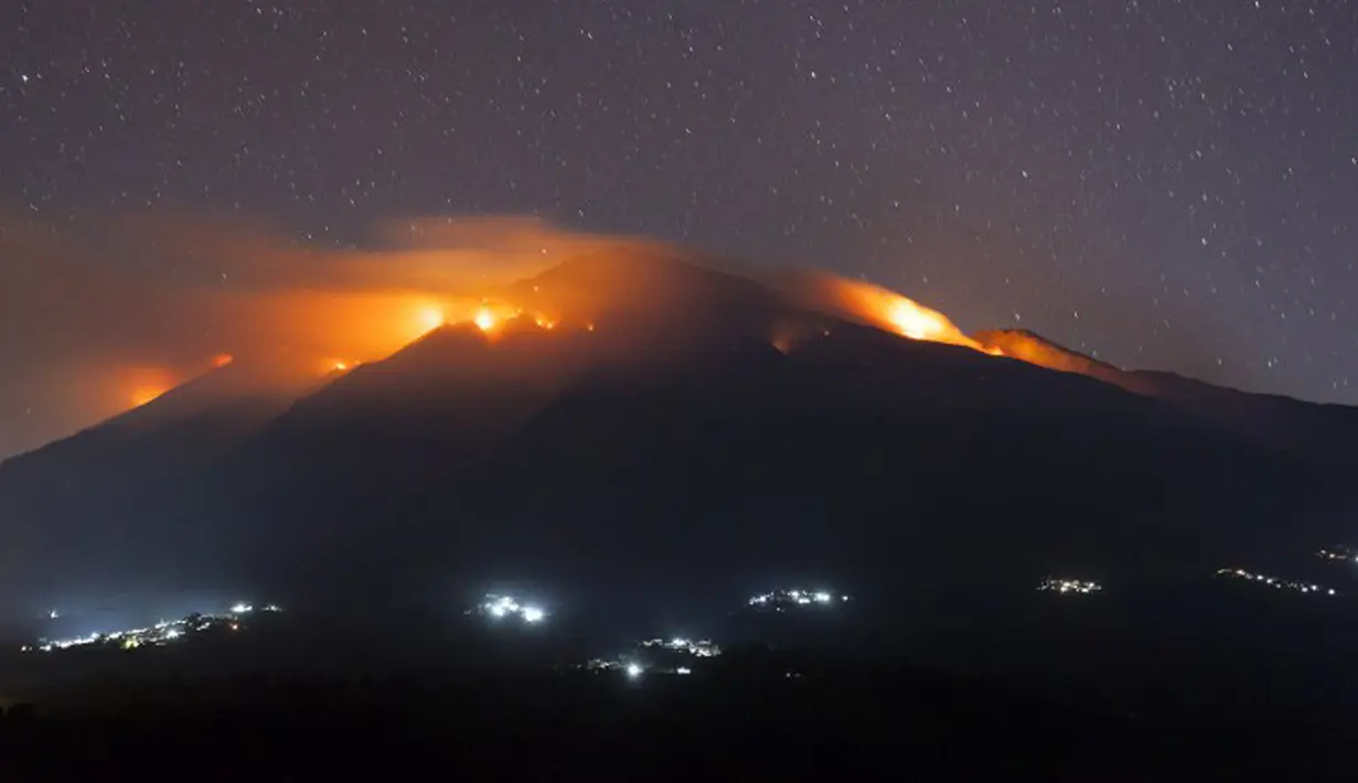 Sejumlah titik-titik api kebakaran yang melanda lereng Gunung Merbabu terlihat dari Kecamatan Magelang, Jawa Tengah, Jumat (21/8/2015). Kebakaran yang sudah terjadi sejak dua hari yang lalu itu diduga akibat musim kemarau. (AFP PHOTO/SURYO WIBOWO)