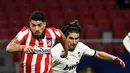 Penyerang Atletico Madrid, Luis Suarez (kiri) bersaing dengan gelandang Valencia, Carlos Soler pada jornada ke-20 Liga Spanyol di Wanda Metropolitano, Senin (25/1/2021) dini hari WIB. Atletico Madrid memetik kemenangan 3-1 atas Valencia. (PIERRE-PHILIPPE MARCOU/AFP)