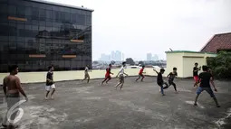 Sejumlah remaja bermain futsal di atas gedung di Pasar Mampang, Jakarta, Rabu (12/7). Sehingga anak-anak dari kalangan ekonomi yang kurang mampu terpaksa memanfaatkan tempat yang bukan semestinya. (Liputan6.com/Faizal Fanani)