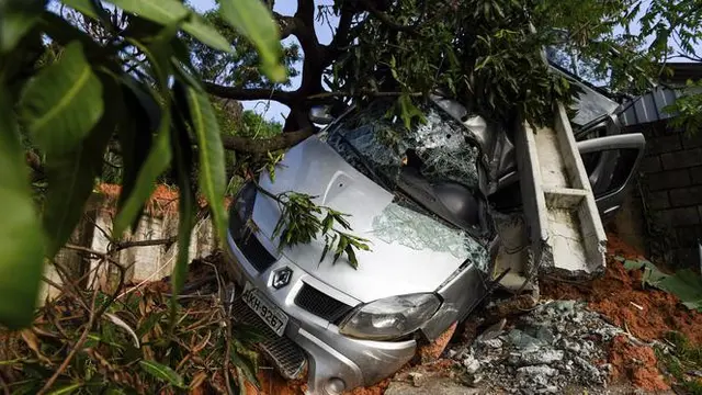 Sebuah mobil terkubur dalam lumpur setelah tanah longsor yang disebabkan oleh hujan lebat di Belo Horizonte, Brasil (27/1/2020).