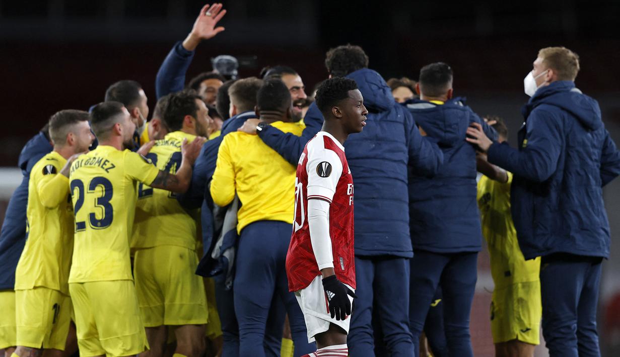 Reaksi kecewa striker Arsenal, Eddie Nketiah di depan para pemain Villarreal yang merayakan kemenangan pada laga leg kedua babak semifinal Liga Europa 2020/2021 di Emirates Stadium, London (6/5/2021). Arsenal kembali lolos ke babak semifinal Liga Europa pada musim 2020/2021 menghadapi Villarreal. Pada leg pertama Arsenal takluk 1-2 di kandang Villarreal (29/4/2021) dan pada leg kedua Arsenal hanya mampu bermain imbang 0-0 dan gagal maju ke partai final. (AFP/Adrian Dennis)