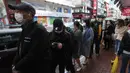 Warga mengantre untuk mendapatkan masker wajah gratis di luar sebuah toko di Tsuen Wan, Hong Kong, Selasa (28/1/2020). Hong Kong terkonfirmasi memiliki delapan kasus infeksi virus corona. (AP Photo/Achmad Ibrahim)