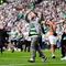 Pendukung Glasgow Celtic masuk lapangan usai tim kesayangan mengalahkan Hearts untuk memastikan gelar Liga Skotlandia musim ini. (AP/Andrew Milligan)