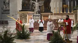Paus Fransiskus memegang ranting pohon palem saat memimpin Misa Minggu Palma di St. Peter's Basilica, Vatikan, Minggu (5/4/2020). Misa hanya diikuti sejumlah petugas yang tetap menjaga jarak untuk menghindari penyebaran virus corona COVID-19. (AP Photo/pool/Alberto Pizzoli)