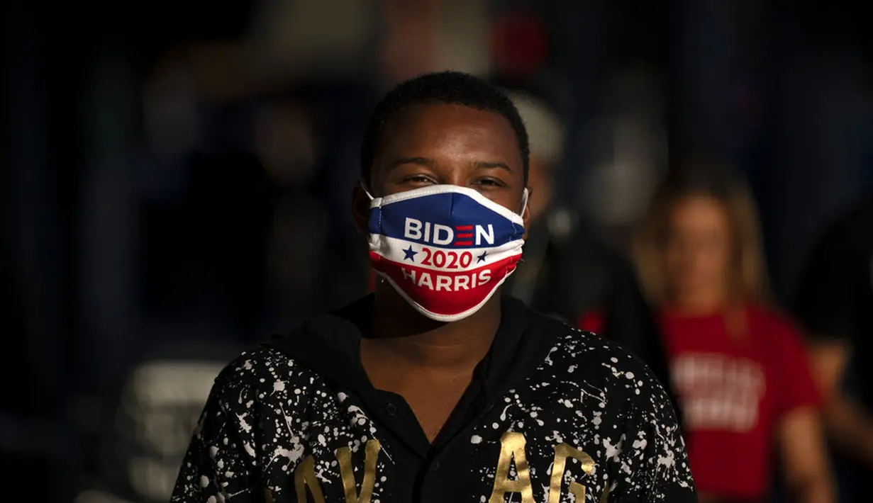 Seorang pria yang mengenakan masker Biden Harris 2020 berjalan di sepanjang jalan di bagian Hollywood Los Angeles, California, Amerika Serikat, Kamis (12/11/2020). California menjadi negara bagian kedua selain Texas yang mencatat 1 juta kasus infeksi COVID-19. (AP Photo/Jae C. Hong)