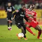 Pemain Bayer Leverkusen&nbsp;Jeremie Frimpong (kiri) dan Kelvin Yeboah dari Augsburg bertarung memperebutkan bola dalam pertandingan Bundesliga Jerman di WWK Arena, Augsburg, Jerman, Jumat, 3 Februari 2023. (Matthias Balk/dpa via AP)