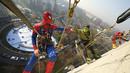 Sejumlah orang berpakaian superhero turun dari atap memberi kejutan di jendela kamar pasien anak di bangsal Pediatri rumah sakit San Paolo di Milan, Italia, Rabu (15/12/2021). Saat beraksi, para superhero memanjat dengan menggunakan tali dibekali alat pengaman yang lengkap. (AP Photo/Luca Bruno)