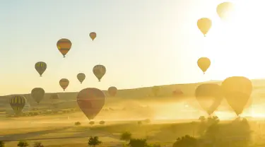 Balon udara panas lepas landas saat akan terbang di atas Nevsehir di wilayah Cappadocia, Turki (5/9). Cappadocia adalah tempat yang unik yang tujuan utama wisatawan yang datang ke Turki. (AFP Photo/Yasin Akgul)