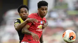 Striker Manchester United, Marcus Rashford, berebut bola dengan bek Southampton, Kyle Walker-Peters, pada laga lanjutan Premier League pekan ke-35 di Stadion Old Trafford, Selasa (14/7/2020) dini hari WIB. Manchester United bermain imbang 2-2 atas Southampton. (AFP/Peter Powel/pool)