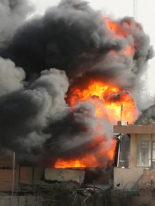 Kepulan asap hitam membumbung dari kebakaran gudang surat suara terbesar Irak di Baghdad, Minggu (10/6). Gudang tersebut menyimpan surat suara dari Al Russafa, salah satu wilayah pemilihan terbesar di bagian timur Baghdad. (AP/Karim Kadim)
