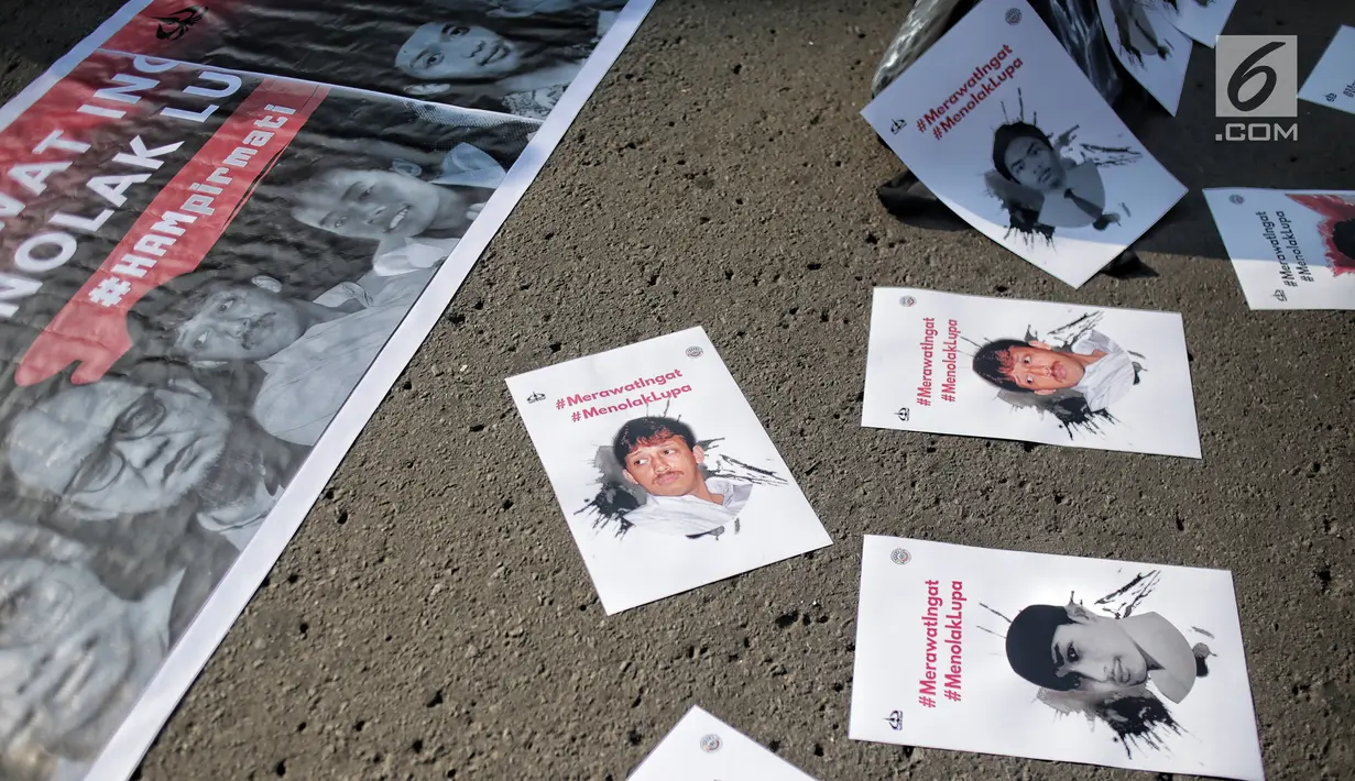 Sejumlah poster terlihat selama aksi bertajuk #MerawatIngat #MenolakLupa saat car free day (CFD) di Bundaran HI, Jakarta, Minggu (5/5/2019). Aksi tersebut bertujuan untuk mengingatkan bahwa masih banyak kasus-kasus pelanggaran HAM berat yang belum terselesaikan. (Liputan6.com/Faizal Fanani)