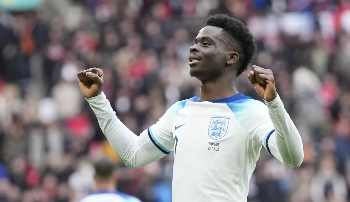 Pemain Inggris, Bukayo Saka, melakukan selebrasi setelah mencetak gol ke gawang Ukraina pada laga Kualifikasi Euro 2024 Grup C di Stadion Wembley, Minggu (26/3/2023). (AP Photo/Alastair Grant)