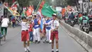 Siswa-siswi SD membawa bendera negara peserta Asian Games 2018 untuk menyambut Kirab Obor di kawasan Jati Padang, Pasar Minggu, Rabu (15/8). Mereka memenuhi jalanan untuk menyaksikan langsung Pawai Obor Asian Games 2018. (Liputan6.com/Faizal Fanani)