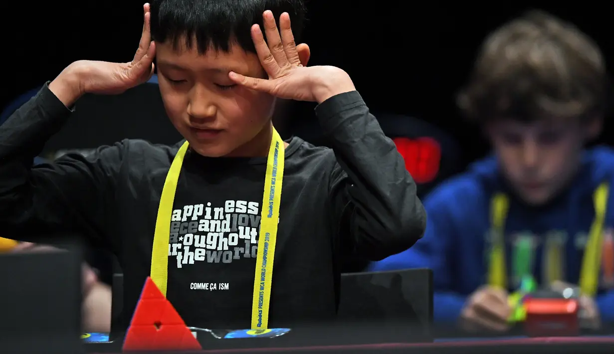 Ekspresi seorang anak saat mengikuti kejuaraan kubus Rubik Dunia di Melbourne, Australia (12/7/2019). Permainan Kubus Rubik 3x3x3, ditemukan oleh Profesor Rubik dari Hongaria pada tahun 1974. (AFP Photo/William West)