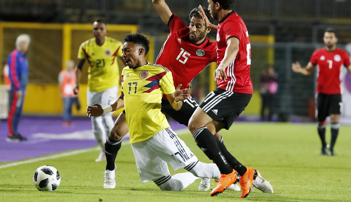 Pemain Kolombia, Johan Mojica (kiri) jatuh saat mencoba melewati dua pemain Mesir pada laga uji coba di "Atleti Azzurri d'Italia Stadium”, Bergamo, (1/6/2018). Mesir dan Kolombia bermain imbang 0-0. (AP/Antonio Calanni)